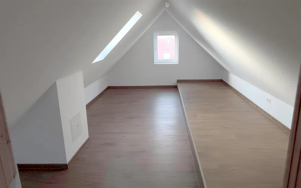 Fertig ausgebauter Dachboden mit Dachfenster und neuem Boden.