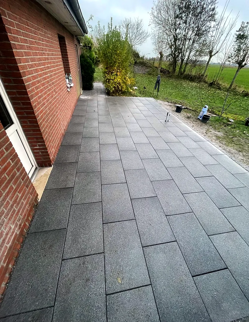 Terrasse aus großen Platten am Haus.