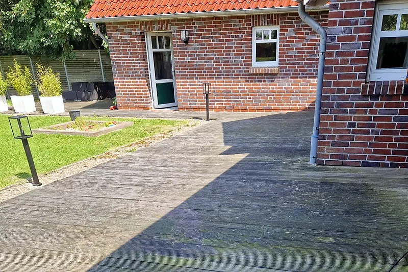 Dieselbe Holzterrasse vorher, vergraut und bemoost.