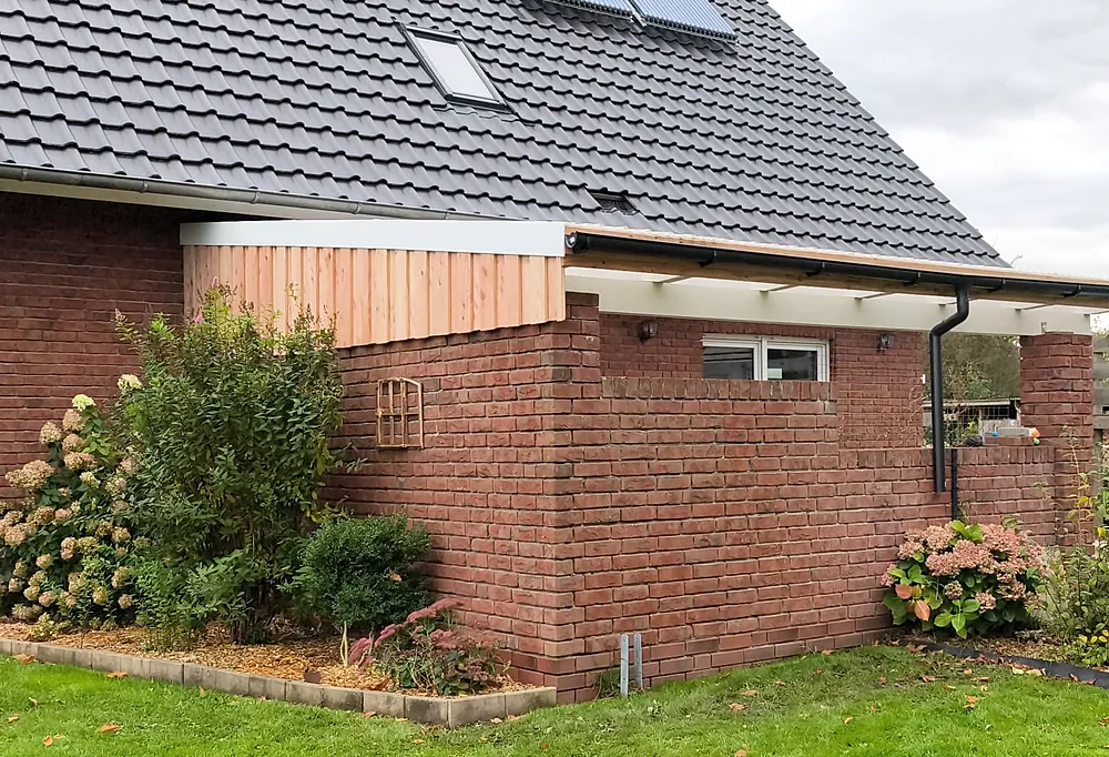 Terrassenüberdachung mit Holzverkleidung am Klinkerhaus.